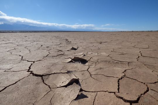 oranger, rissiger Boden vor blauem Himmel