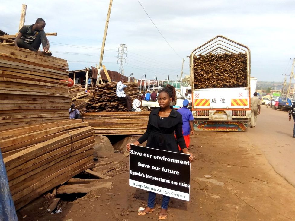 Die ugandische Klimaaktivistin Hilda Nakabuye protestiert vor Holzhändlern gegen Abholzung