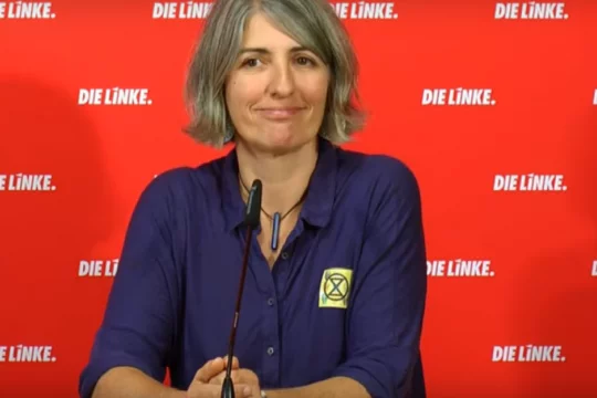 Cléo Mieulet vor einer roten Wand mit Aufschrift