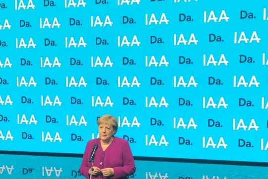 Kanzlerin Merkel vor einer Werbewand der IAA.