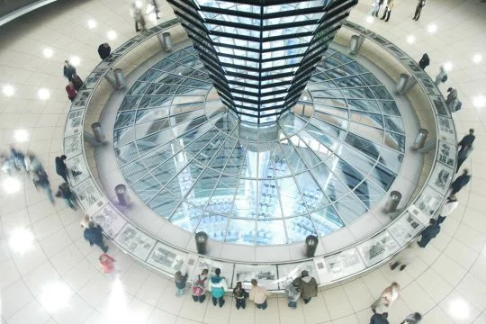 Besucher blicken von der Reichstagskuppel hinunter in den Plenarsaal des Bundestags