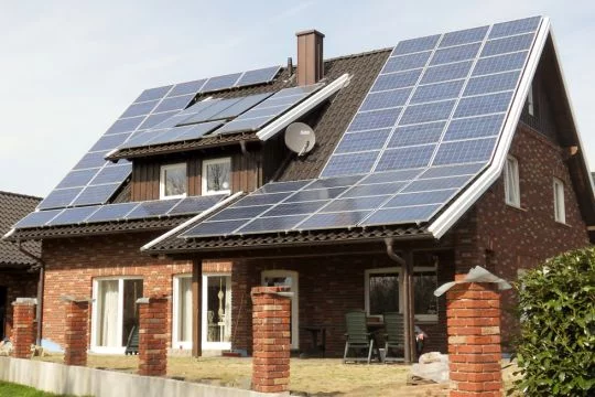 Ein neues Einfamilienhaus mit einem Dach voller Solarpaneele.