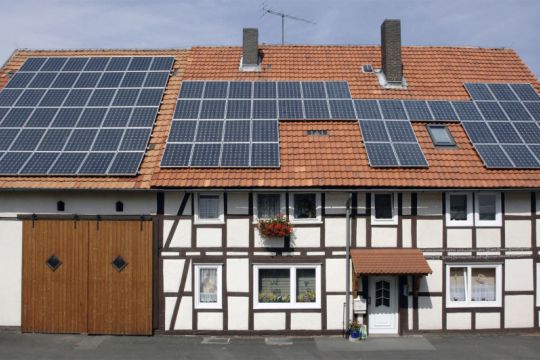 Zweistöckiges Fachwerkhaus mit Solarpaneelen fast auf dem ganzen Dach.