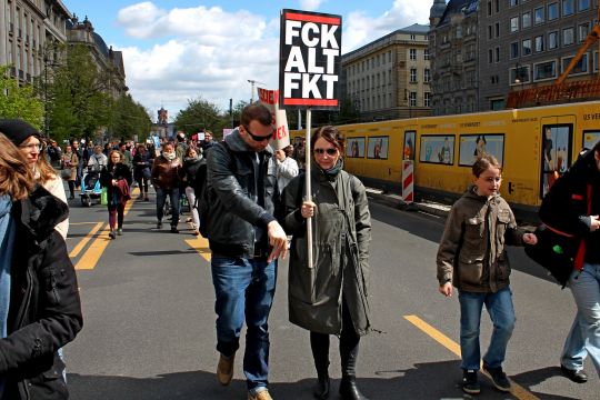 Zwei Menschen halten auf einer Demonstration ein Schild mit der Aufschrift "FCK ALT FKT". 