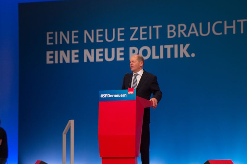 Olaf Scholz spricht an einem roten Pult mit der Aufschrift "SPD erneuern", hinter ihm steht an einer blauen Wand: "Eine neue Zeit braucht eine neue Politik."