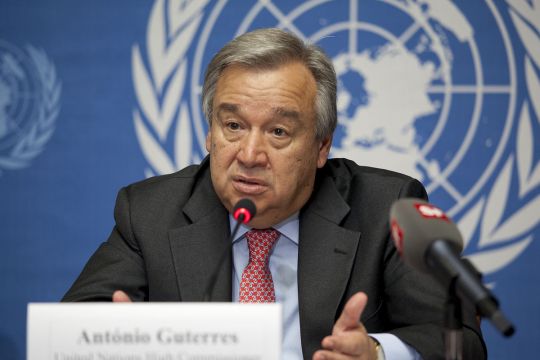 António Guterres vor Flagge der Vereinten Nationen