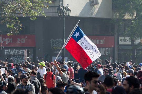Demonstration in Santiago mit chilenischer Fahne, auf der steht: "Wir haben genug, wir schließen uns zusammen".