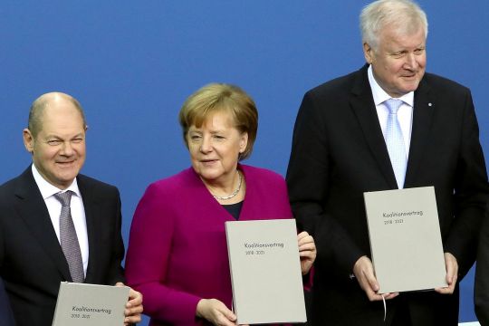 Scholz, Merkel, Seehofer halten lächelnd je ein Exemplar des neuen Koalitionsvertrags