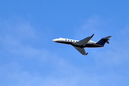 Weißes Flugzeug an strahlend blauem Himmel