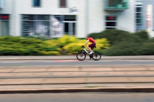 Sportlicher Radfahrer auf breiter Hauptstraße.