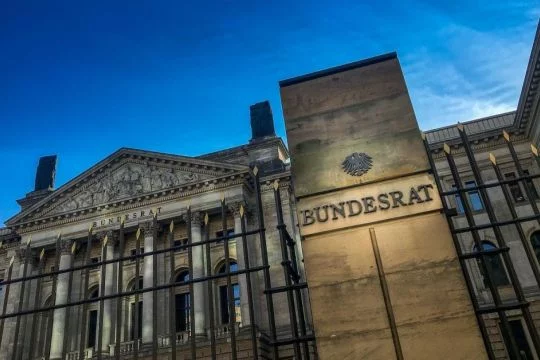 Das Gebäude des Bundesrates von schräg unten aufgenommen bei dunklem Himmel.