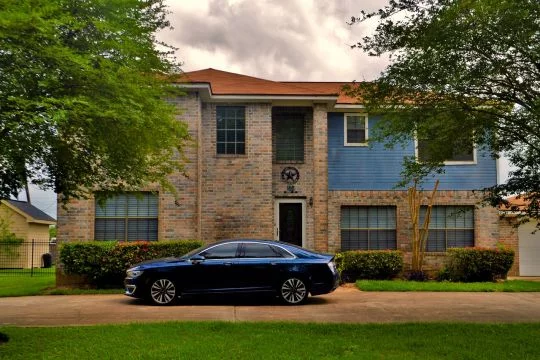 Limousine vor Villa, düsterer Himmel