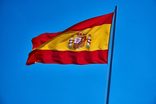 Spanische Flagge vor blauem Himmel