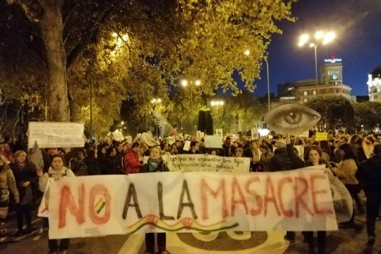 Menschenmasse auf der Straße mit Front-Transparent "No a la masacre"
