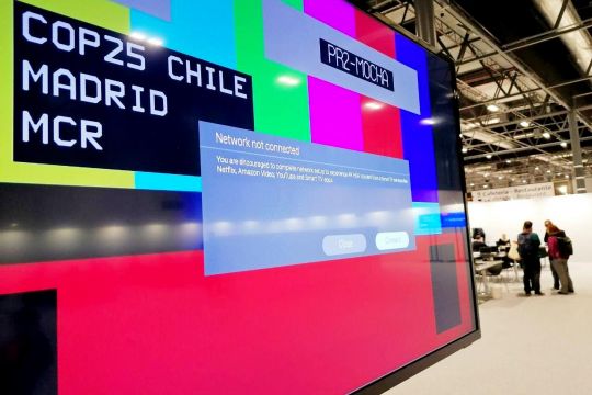 Bildschirm mit Fehlermeldung: "COP 25 Chile Madrid, Network not connected", im Hintergrund Halle mit Arbeitsplätzen