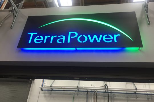 Der blau erleuchtete Schriftzug "Terrapower" auf einem Portal in einer Halle.