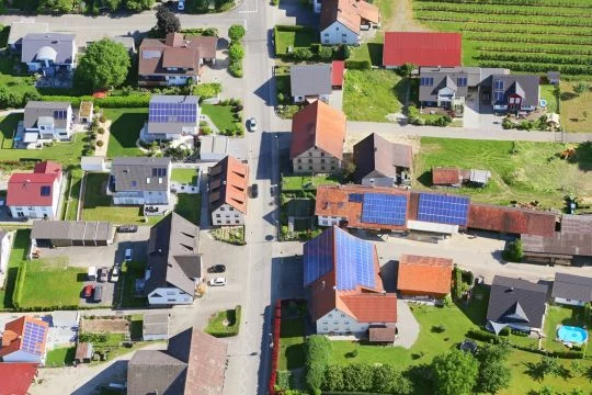 Luftaufnahme einer Siedlung, etliche Häuser haben Solardächer.