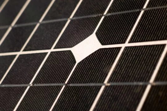 Schwarze Oberfläche eines Solarpaneels mit weißen Streifen zwischen den Modulen.