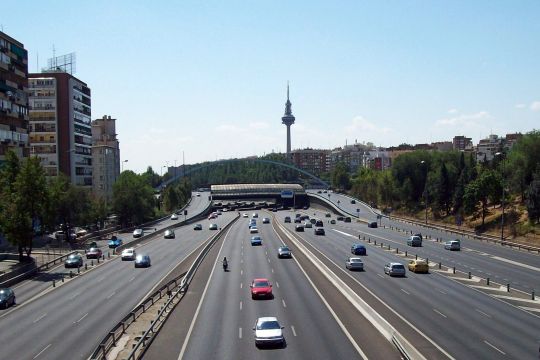 Madrid: Große Autobahn neben Plattenbauten, im Hintergrund Fernsehturm