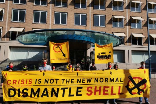 Protestierende vor Shell-Gebäude mit gelbem Transparent: "Crisis is not the new normal – dismantle Shell!"