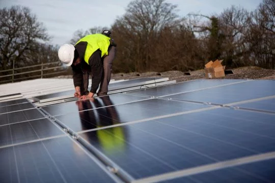 Im englischen Balcombe installiert ein Bauer Solarkollektoren auf dem Dach seiner Scheune.