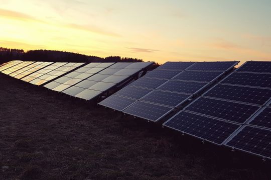 Solaranlagen auf Wiese im Sonnenuntergang