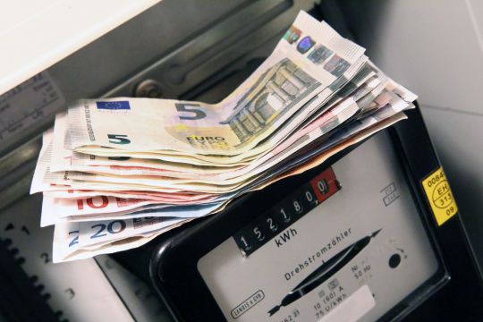 Mehr als 200 Euro in Scheinen liegen auf einem Stromzähler, aufgenommen von schräg oben.