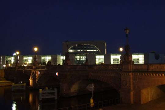 Das Kanzleramt in Berlin bei Nacht, im Vordergrund Spree und Moltkebrücke