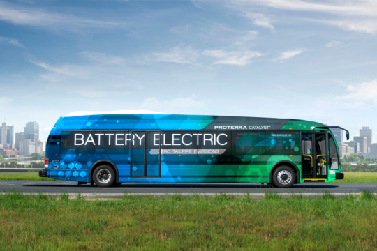 Blau-grüner Bus mit großer Aufschrift 
