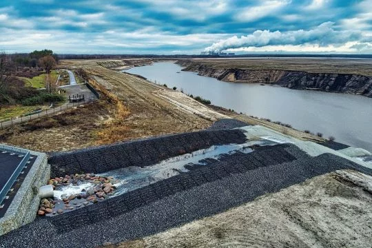 Mit Steinen ausgekleideter Zufluss zum Tagebaurestloch, aus dem einmal ein See werden soll, der aber erst zu einem Viertel gefüllt ist. Aufnahme von Januar 2020.