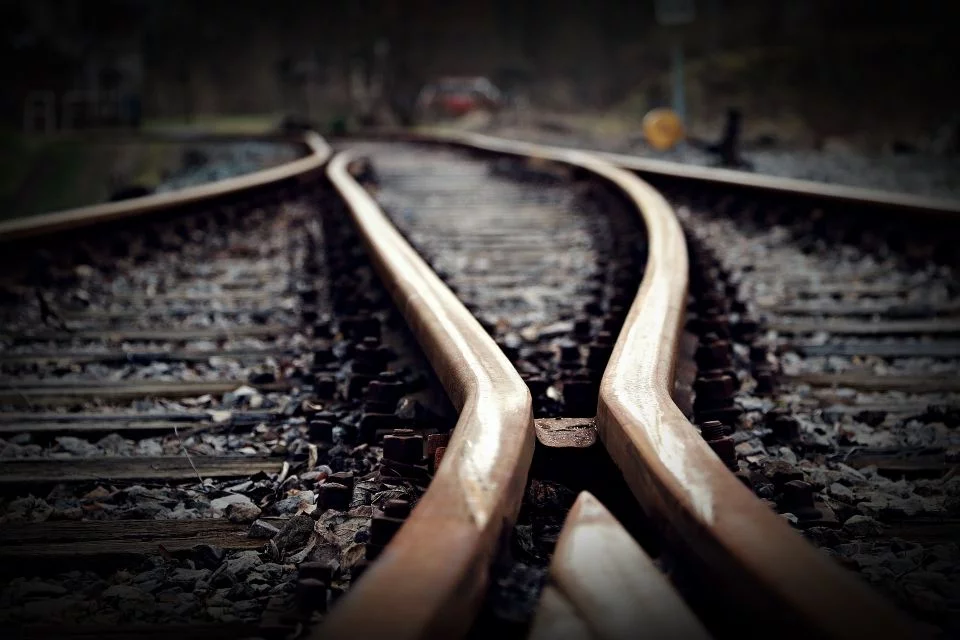 Bahnschienen mit einer Weiche, auf den Schienen liegend aufgenommen.