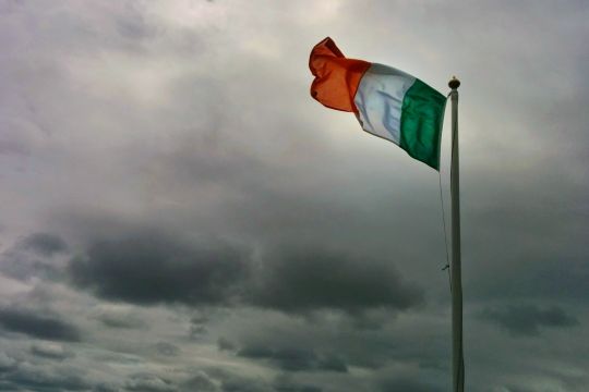 irische Flagge vor stürmischem Himmel