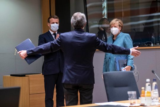 Das Bild zeigt Frankreichs Präsidenten Emmanuel Macron und Bundeskanzlerin Angela Merkel im Gespräch mit EU-Parlamentschef David Sassoli, der die Arme einladend öffnet.