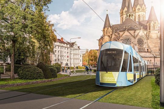 Fotomontage: Moderne Straßenbahn fährt auf begrünter Trasse vor der Ringkirche in Wiesbaden.