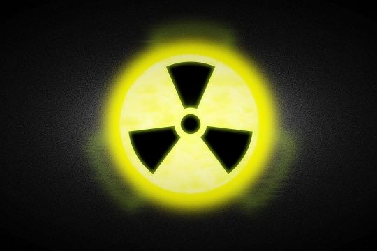 Gelbes Radioaktivitäts-Zeichen vor schwarzem Hintergrund.