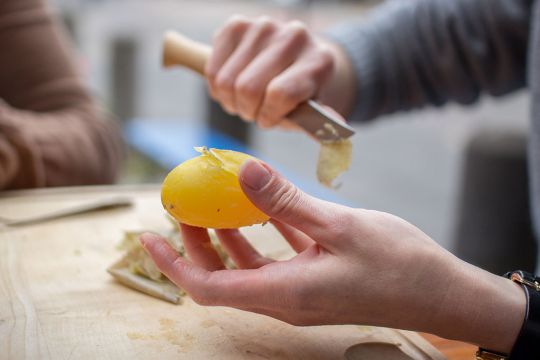 Eine Pellkartoffel wird fachgerecht gepellt.