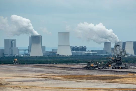 Typische Braunkohle-Mondlandschaft, in der sogar der riesige Kohlebagger klein aussieht, dahinter das große Braunkohlekraftwerk Schwarze Pumpe.