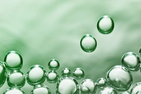 Grüne Gasblasen an der Wasseroberfläche.