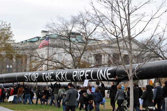 Menschen tragen bei einer Demonstration am Weißen Haus in Washington eine große Pipeline-Attrappe mit der Aufschrift: Stop the KXL Pipeline.
