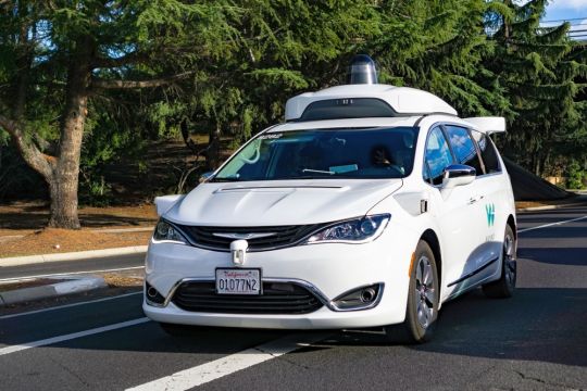 Fahrerloser weißer Pkw des Google-Schwesterunternehmens Waymo fährt auf einer Straße nahe der Google-Zentrale im Silicon Valley.