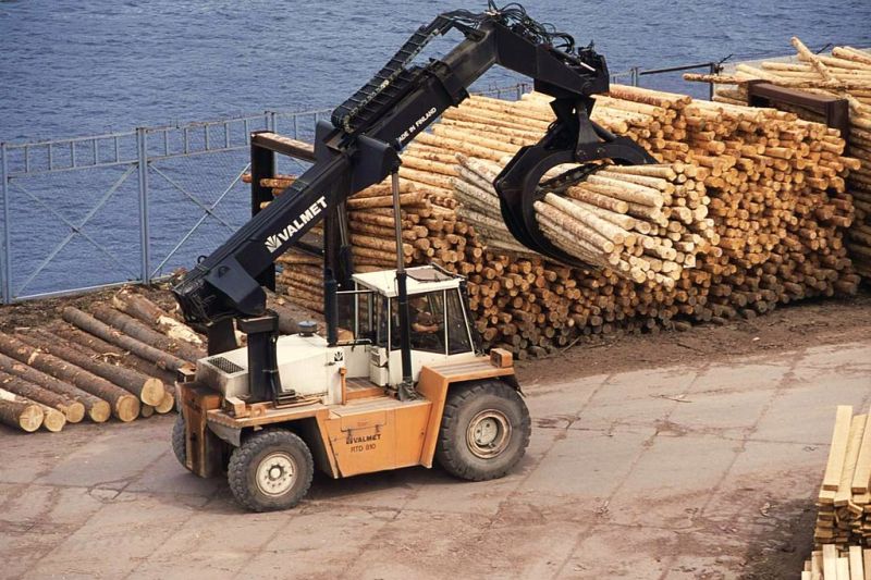 Ein finnisches Kranfahrzeug stapelt Rundholz am Kai eines großen Holzwirtschaftsbetriebs in der russischen Stadt Sokol.
