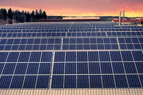 Eine sehr große Fabrikhalle ist komplett mit Solarpaneelen bedeckt.
