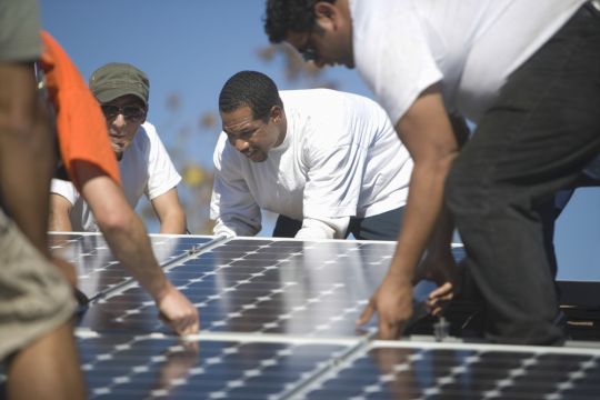 Monteure installieren Solarpaneele.