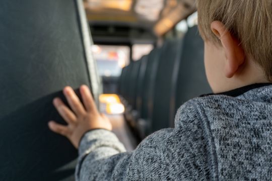 Kinderhand an einer Lehne eines Bussitzes