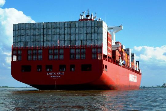 Beladenes Containerschiff von hinten, an der Seite mit der Aufschrift: Hamburg Süd, hinten mit der Aufschrift: Santa Cruz – Monrovia.