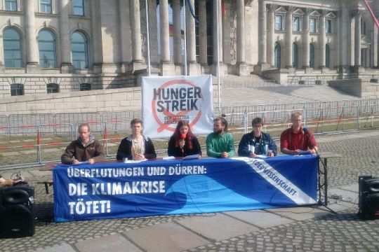 Die sechs jungen Hungerstreikenden auf einem improvisierten Podium vor dem Reichstag im Berliner Regierungsviertel.