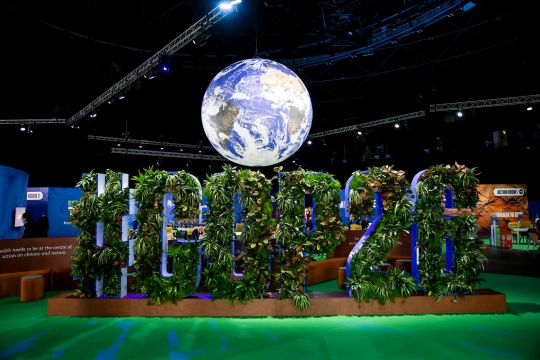 Mit Pflanzen geschmückter Schriftzug der COP 26 im Konferenzzentrum in Glasgow