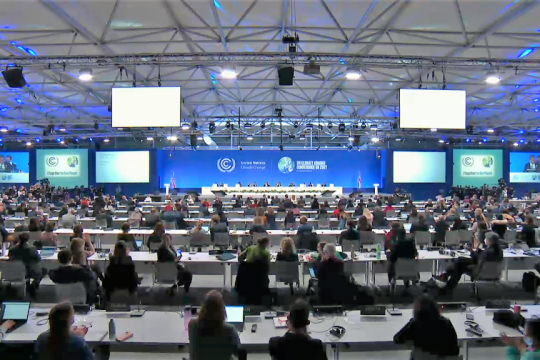 Große Halle mit vielen Tischreihen, an denen die Klimagipfel-Delegierten jeweils mit einigem Abstand sitzen, weit vorn das Podium mit der Konferenzpräsidentschaft.