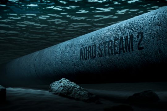 Große, graue Röhre mit Aufschrift "Nord Stream 2" in dunkler Lichtstimmung unter Wasser.