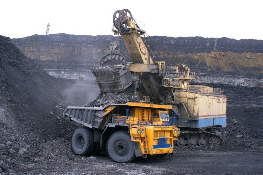 In einem Tagebau belädt ein Kohlebagger einen Riesen-Laster der Marke Belas mit Steinkohle. 
